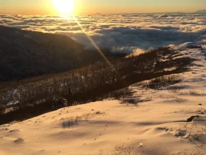 a breathtaking sunset view from a snow-covered mountaintop in Alaska